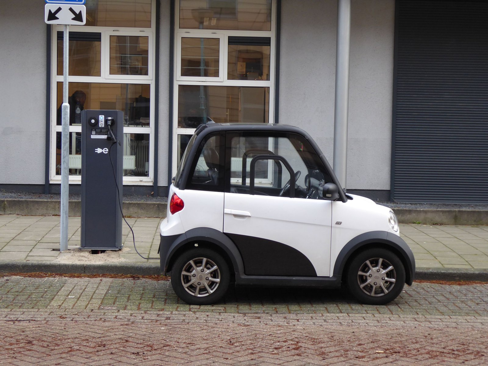 Petite voiture électrique branchée à une borne en ville